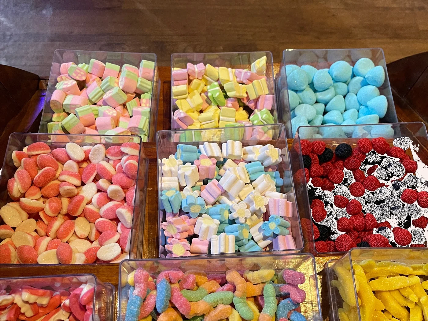 Bandejas coloridas com diversas guloseimas Fini organizadas na estação de doces
